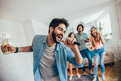 Group of friends playing karaoke at home. Concept about friendship, home entertainment and people